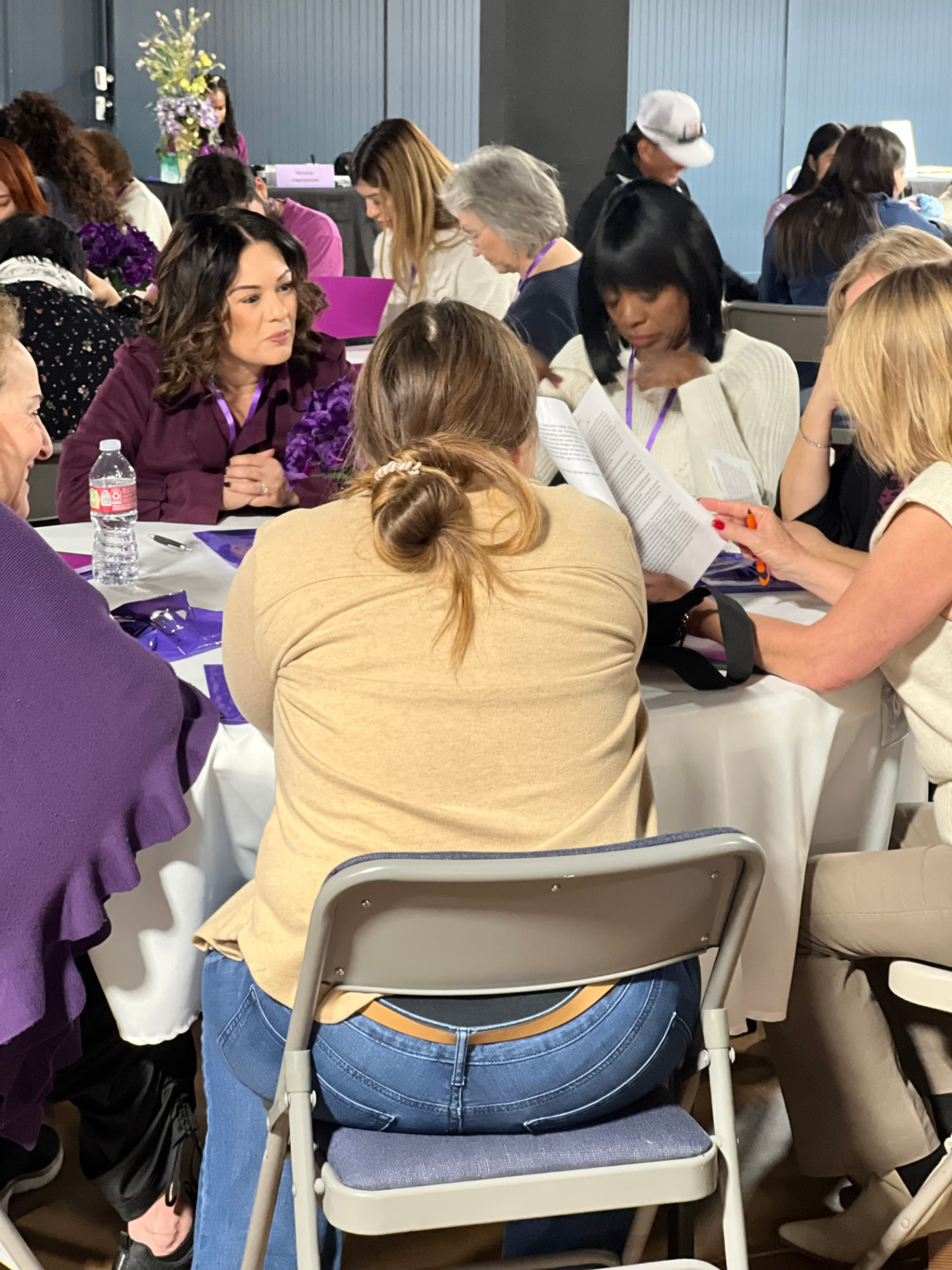 Women in conversation around tables at a Sistership session